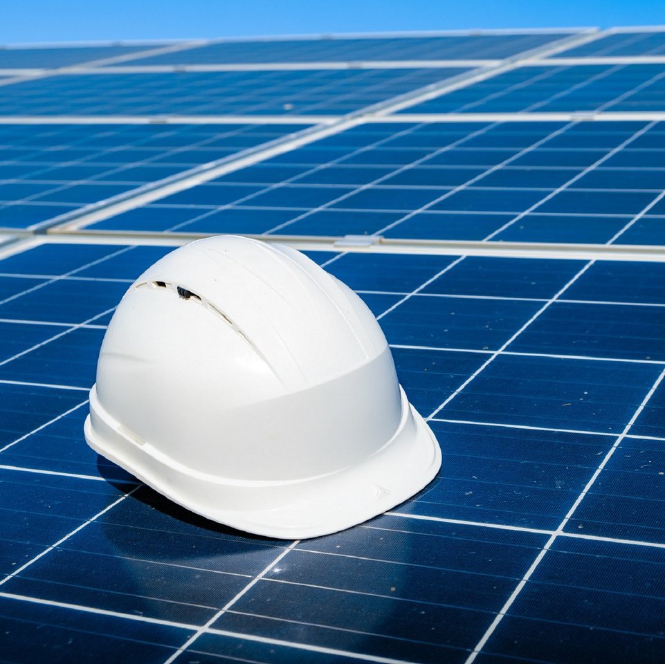 Schmuckbild - Weißer Helm auf Solarzellen