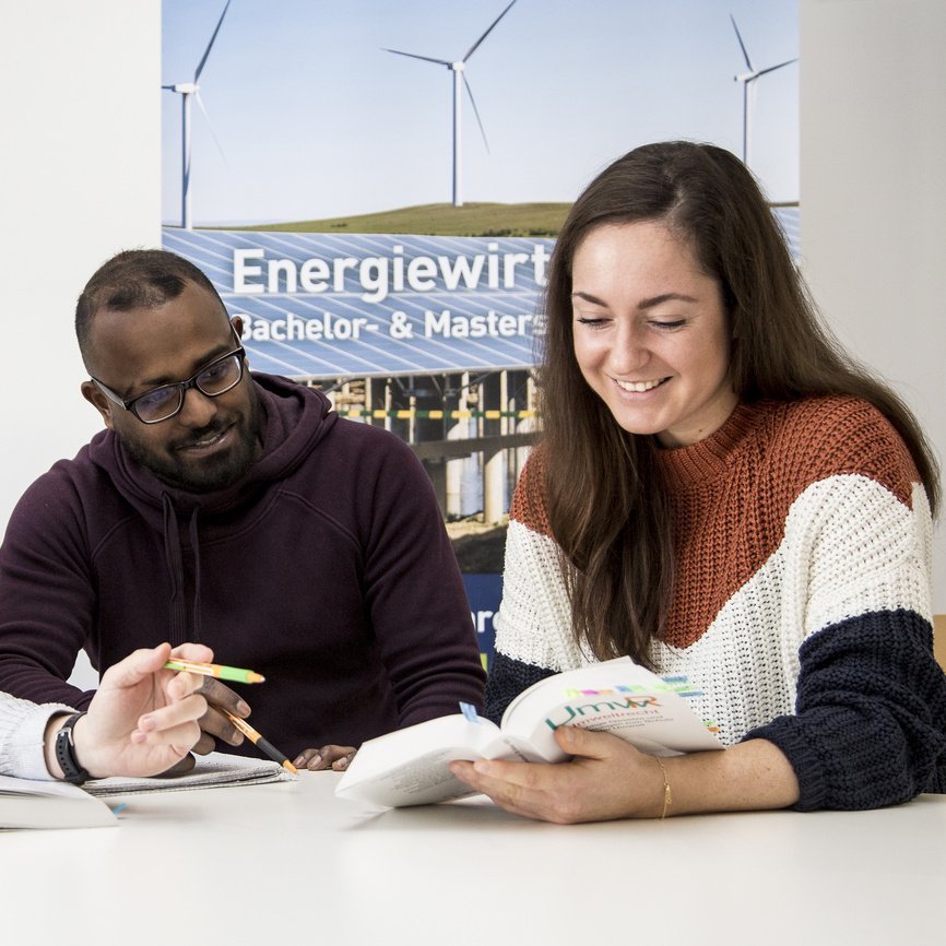 Drei Studierende des Studiengangs Energiewirtschaft Bachelor sitzen gemeinsam an einem Tisch und lernen