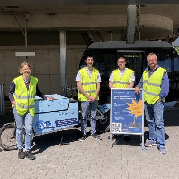 Foto- Verantwortliche des Projektes posieren vor der Gondel und einem Lastenfahrrad