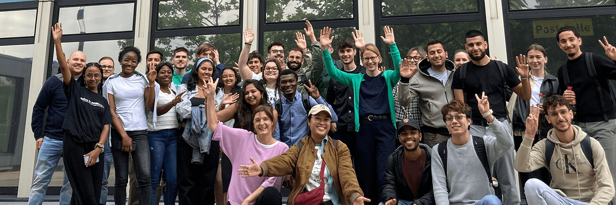 A group photo of exchange students in front of the university's high-rise building